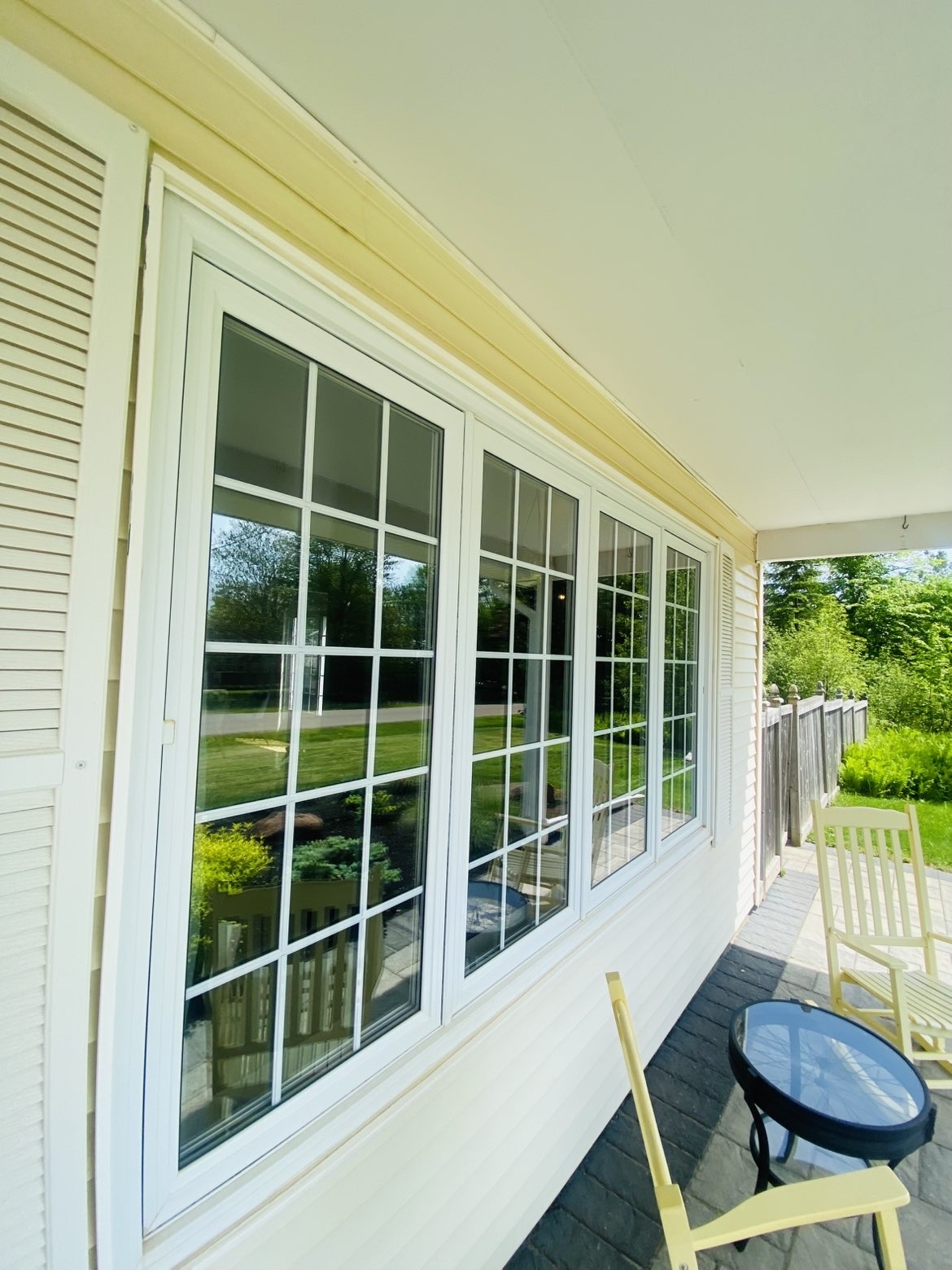Sparkling clean porch windows with grid panes reflecting the front yard